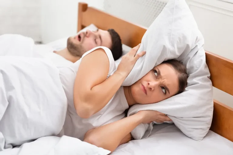 Angry Girlfriend Covering Ears Lying Near Snoring Boyfriend In Bed